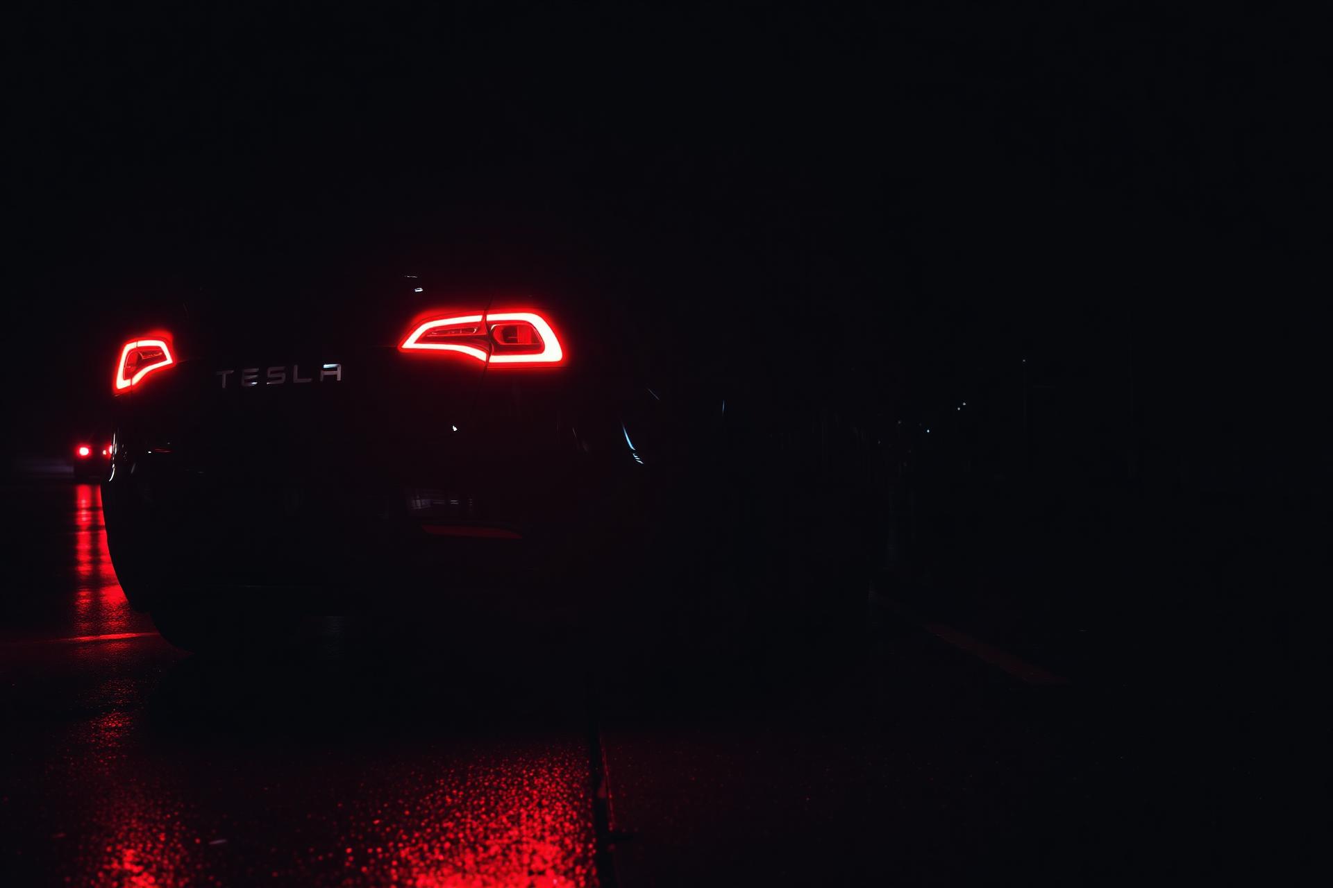 Tesla Model 3 rear with dynamic lighting at night